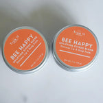 Load image into Gallery viewer, Two tins of True It Naturals Bee Happy lip and body beeswax balm with orange labels on a white background.
