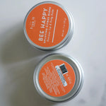 Load image into Gallery viewer, Two tins of True It Naturals Bee Happy beeswax lip and body balm showing front and back labels.

