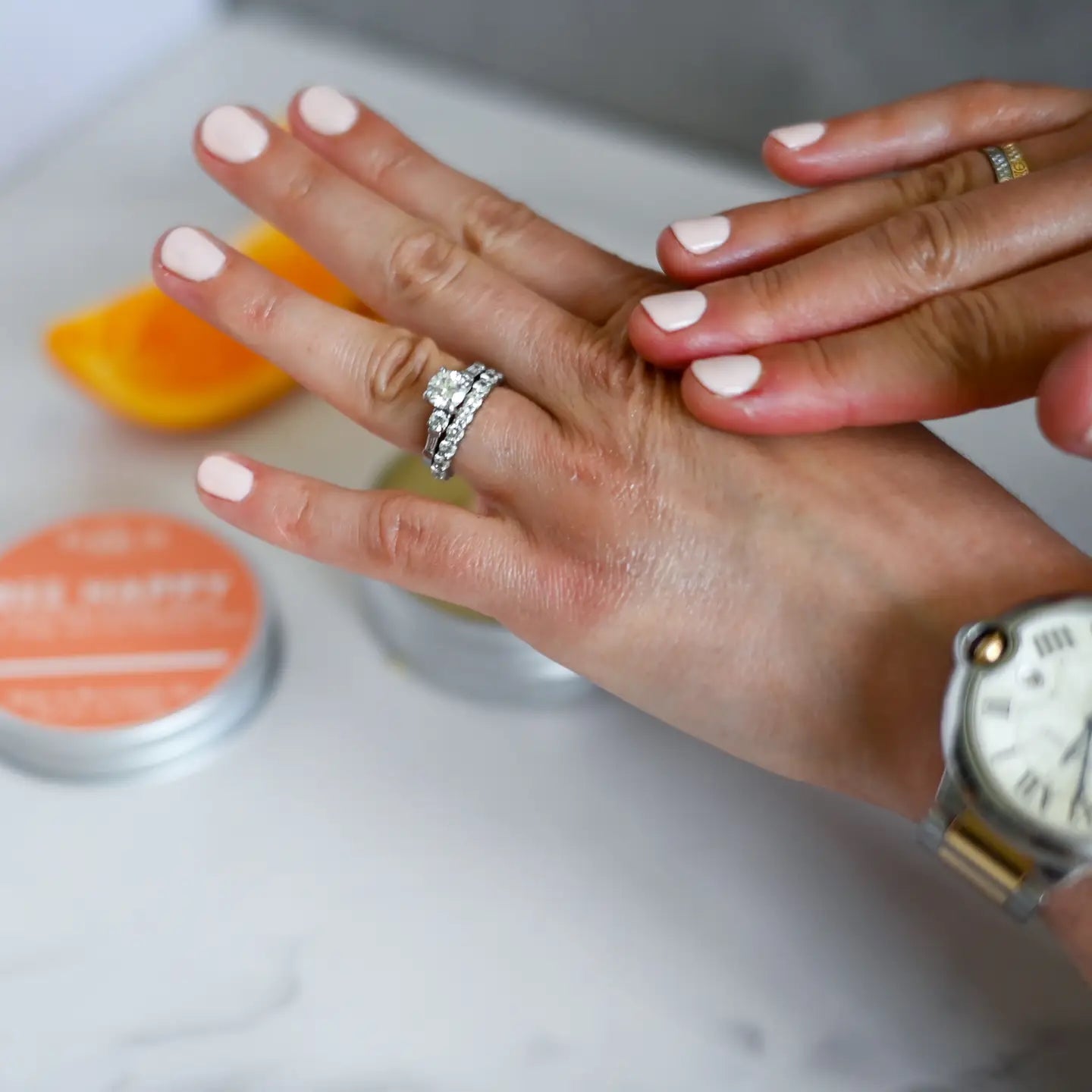 Close-up of two hands rubbing in some of the beeswax balm with blurred background