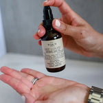 Load image into Gallery viewer, Person holding a bottle of True It Naturals Bee Loved intimacy love and massage oil with a neutral background
