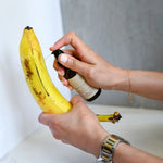 Load image into Gallery viewer, True It Naturals Bee Loved natural beeswax massage oil applied on a banana as a demo.
