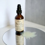 Load image into Gallery viewer, True It Naturals Bee Loved natural beeswax massage oil applied on a surface to show oil on mirror surface.
