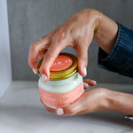 Load image into Gallery viewer, Person opening a jar of Citrus Cream Body Butter.
