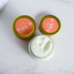 Two containers of Citrus Cream body butter. One with the lid off showing the cream texture.