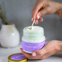 True It Naturals Lavender Cream Body Butter with cap off. Scooping some of the body butter with a wooden spoon.