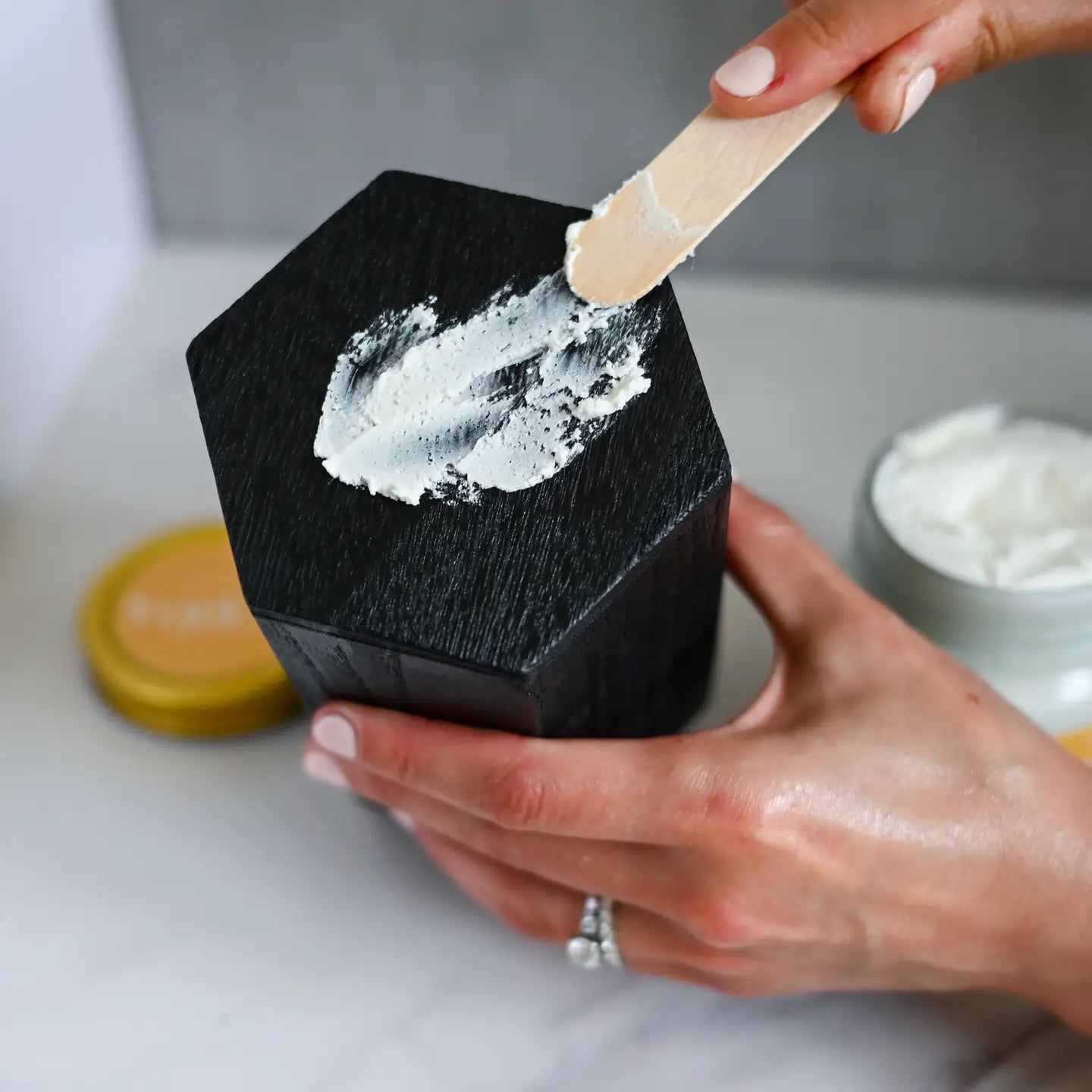 rue It Naturals Lavender Mango Butter Body Butter with cap off. Scooping some of the body butter and showing the texture when applying it.